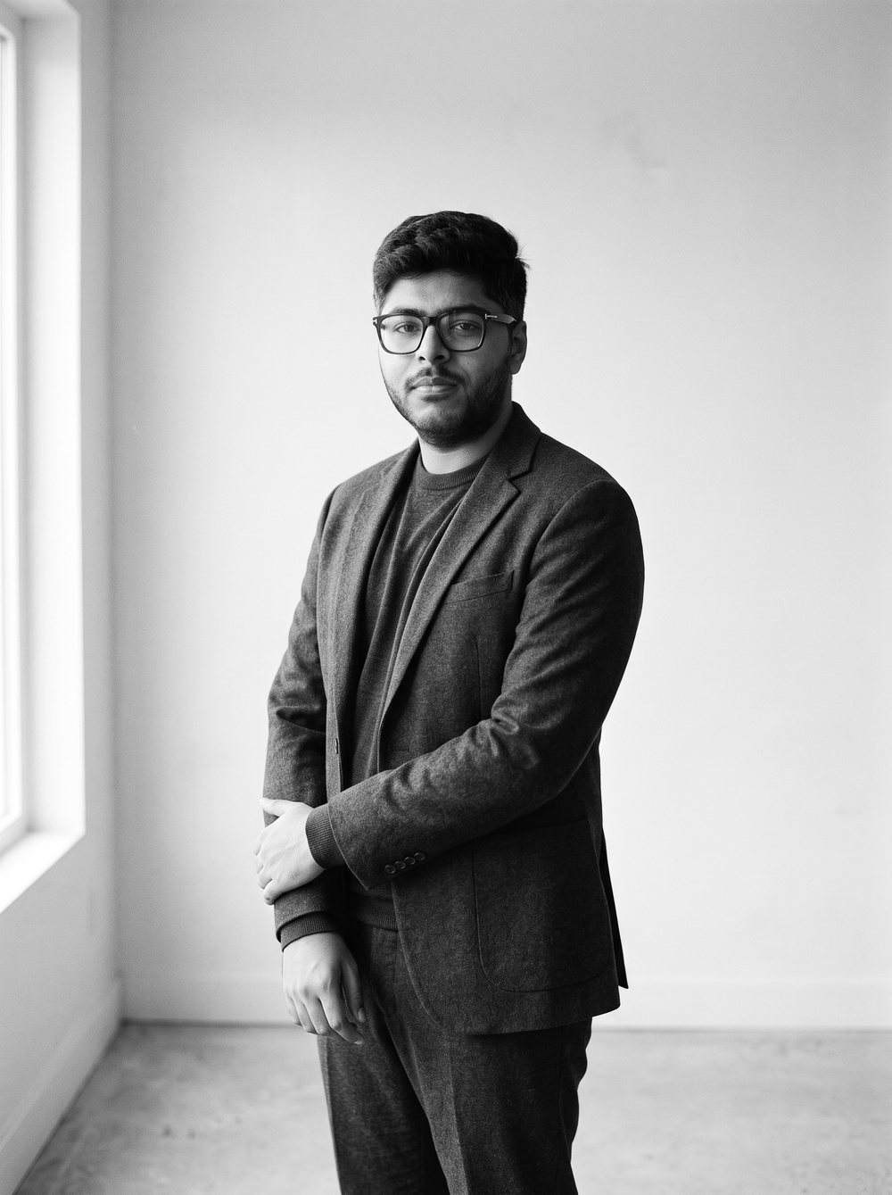 Umer Fayyaz, standing in an empty room, black and white photograph